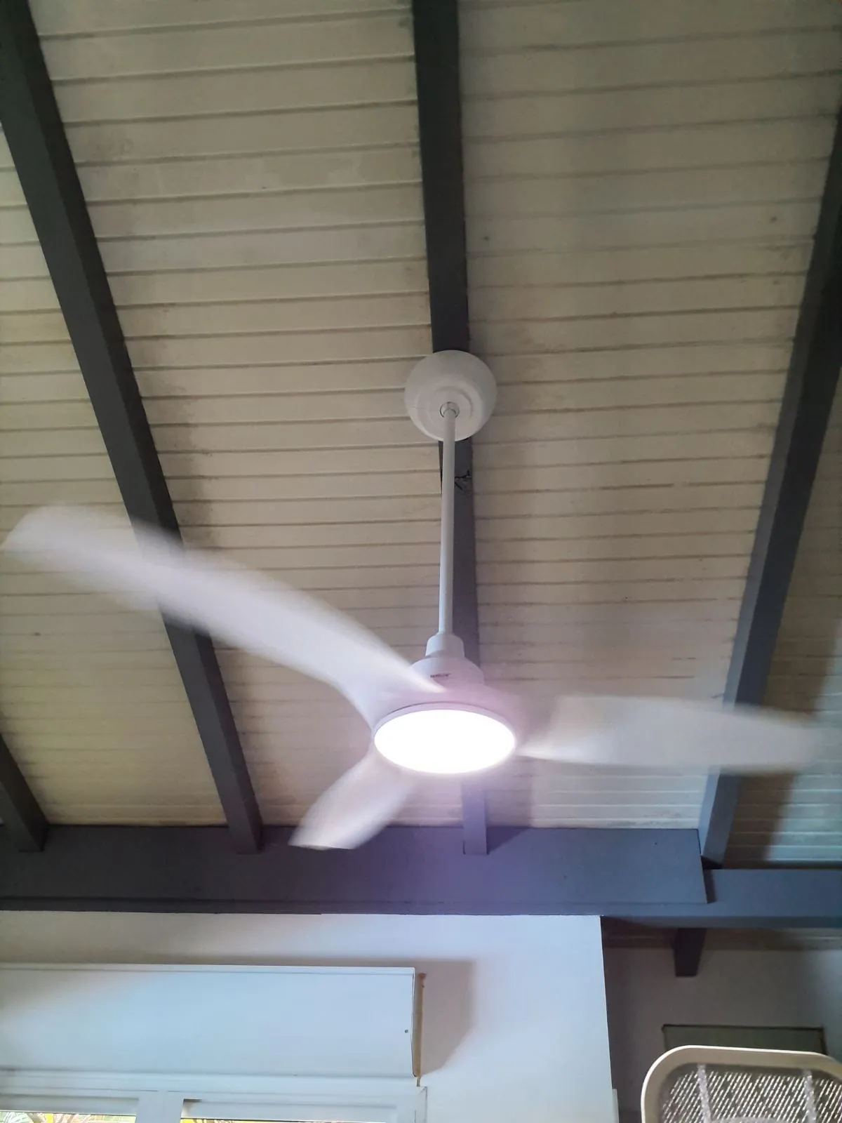 Brasseur d'air FANELITE blanc posé entre les poutres d'une charpente aux Trois-Îlets