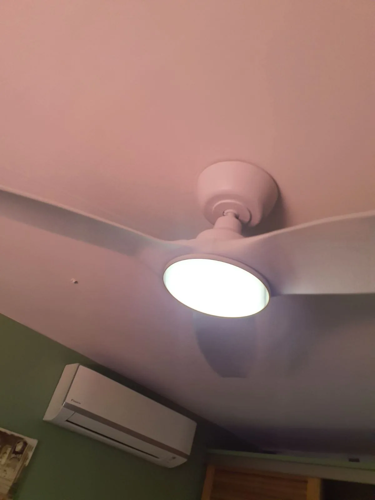 Brasseur d'air FANELITE blanc installé dans une pièce aux murs verts aux Trois-Îlets