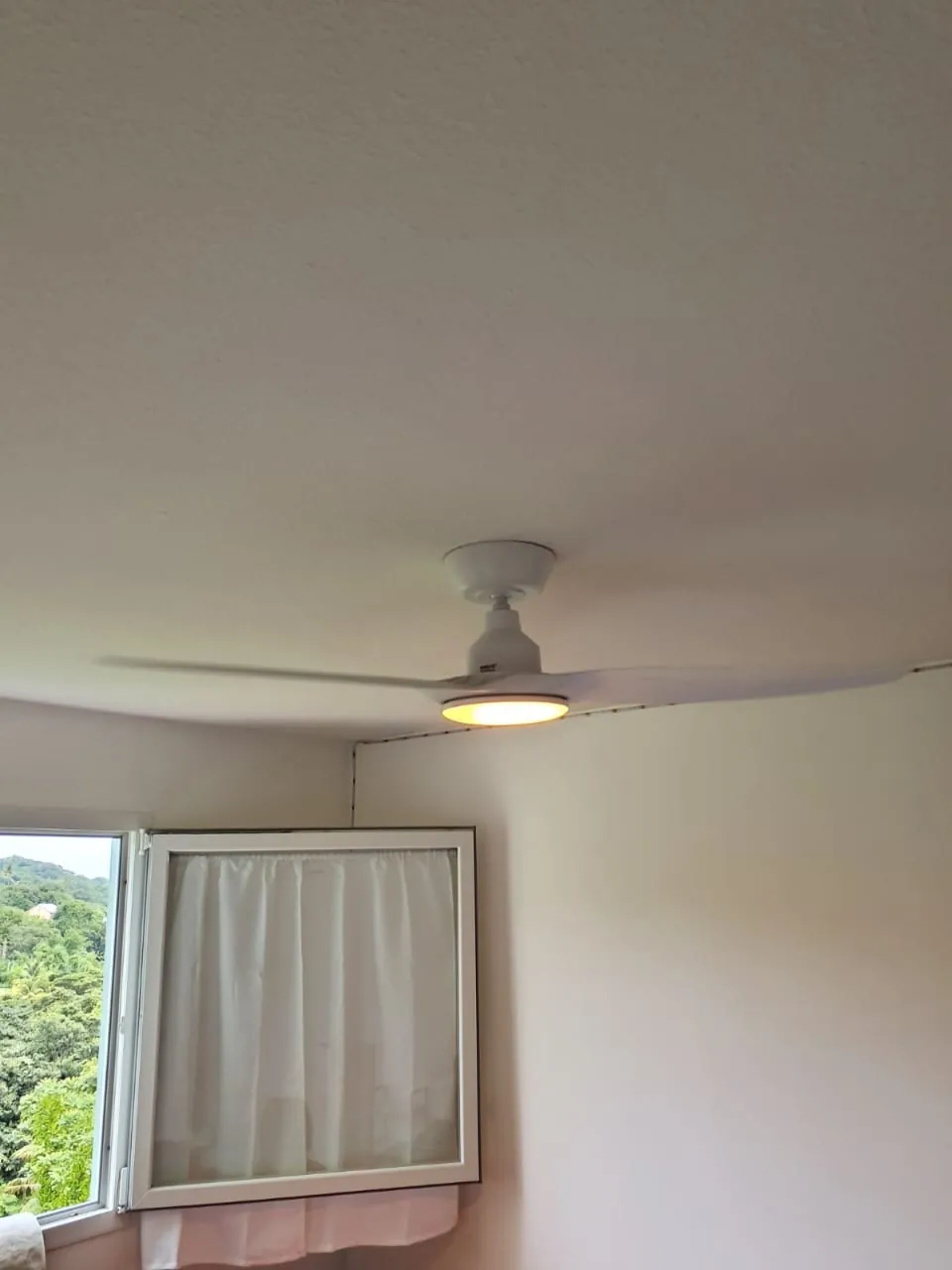 Brasseur d'air FANELITE blanc installé dans une chambre à Sainte-Marie
