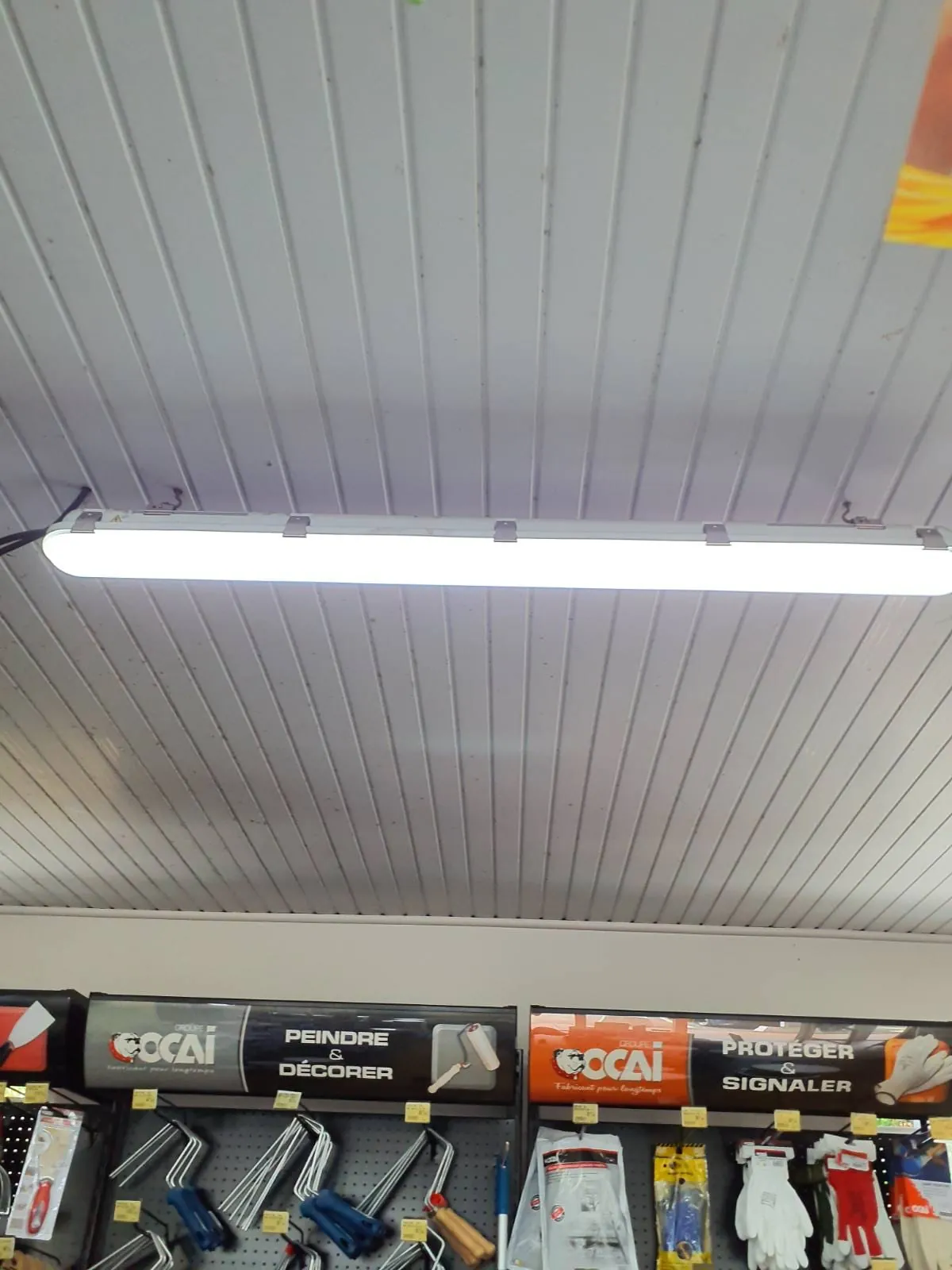 Réglette néon sous le lambris d'un magasin avant la pose de brasseurs FANELITE à Ducos