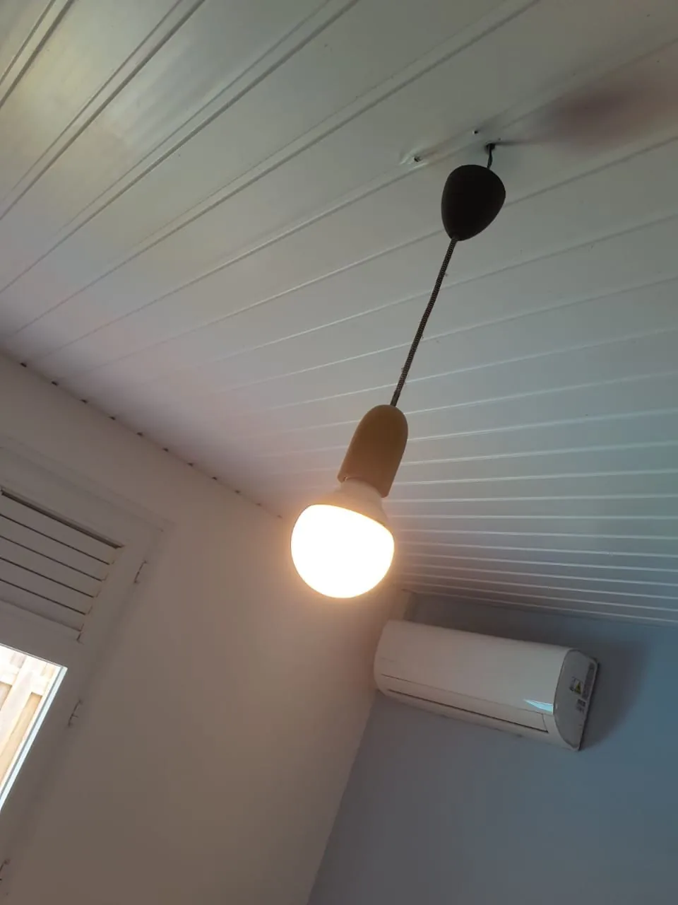 Ampoule nue sous un plafond lambrissé avant la pose d'un brasseur d'air FANELITE à Fort-de-France