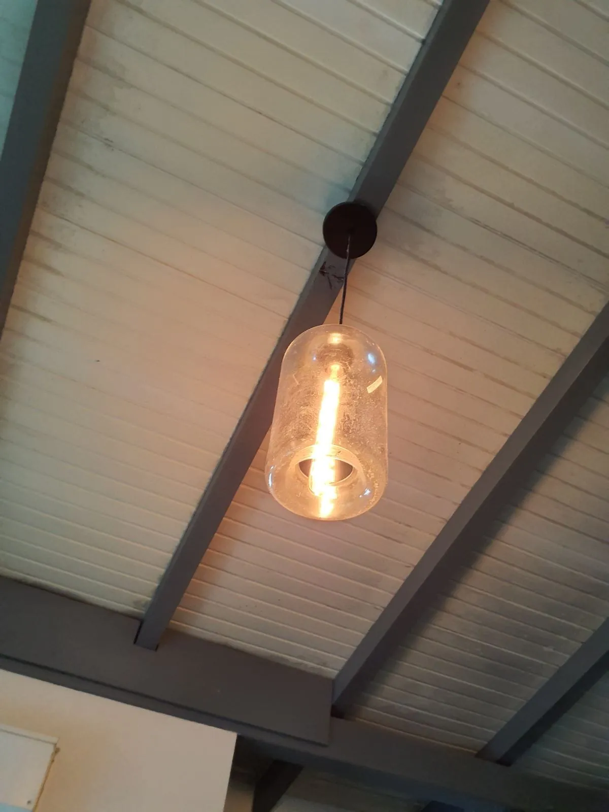Suspension en verre sous une charpente en bois avant la pose d'un brasseur FANELITE aux Trois-Îlets
